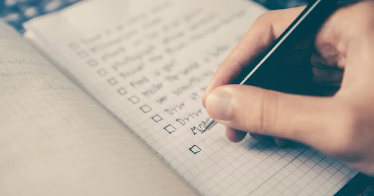 Person writing a list in a notebook
