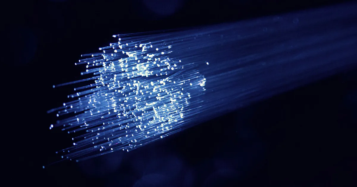 Glowing blue fiber optic strands against a dark background